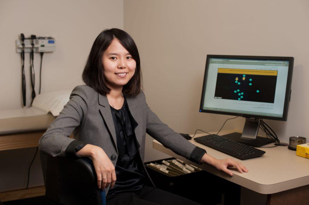 A University of Rochester researcher in front of a computer filled with data